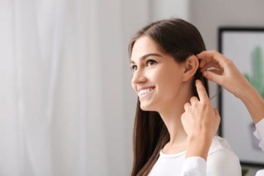 Einer jungen Frau wird ein Hörgerät eingesetzt.