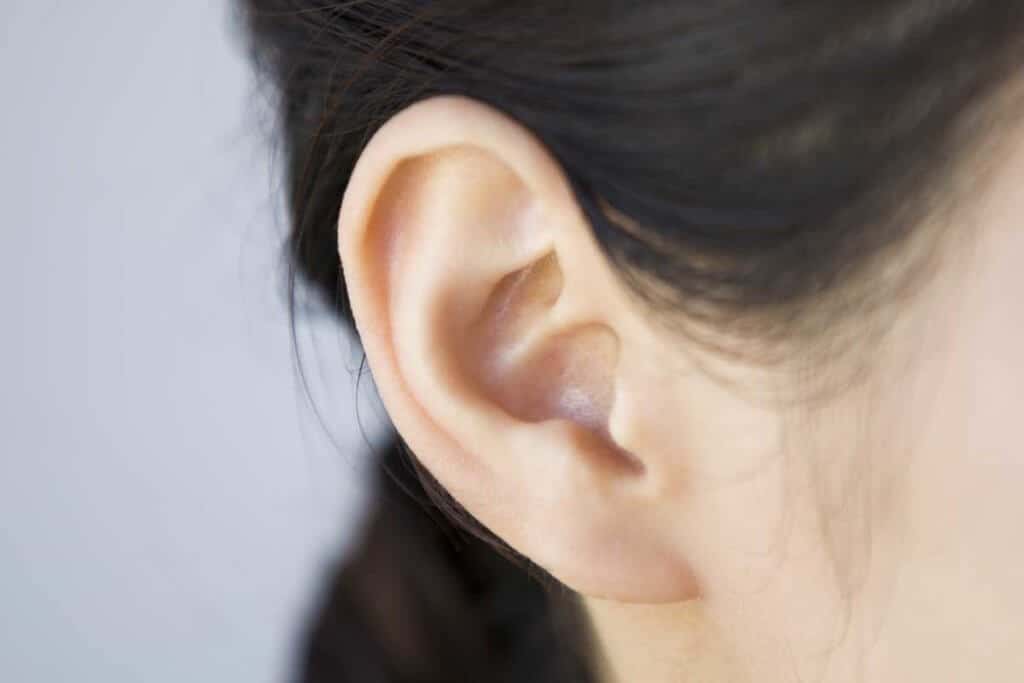 Frauenohr mit unsichtbarem Hörgerät