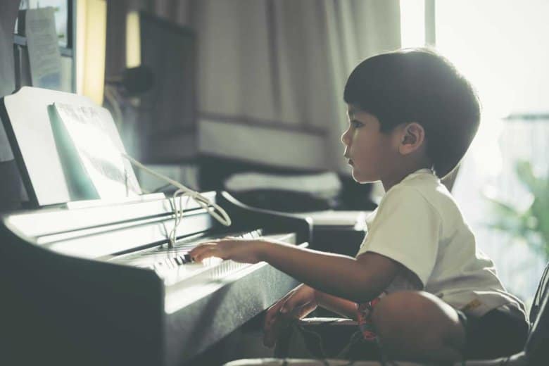 Asiatischer Junge spielt auf dem Klavier