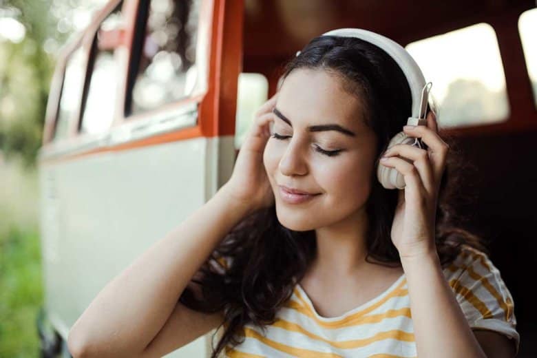 Junge Frau hört in Ihrem Minibus mit Kopfhörern Musik