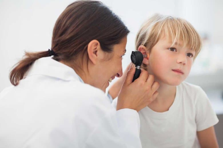 Ärztin untersucht das Ohr eines Kindes