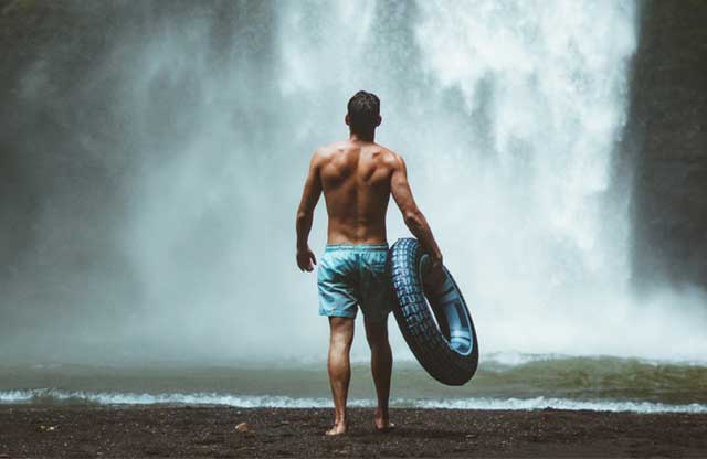 Mann vor Wasserfall