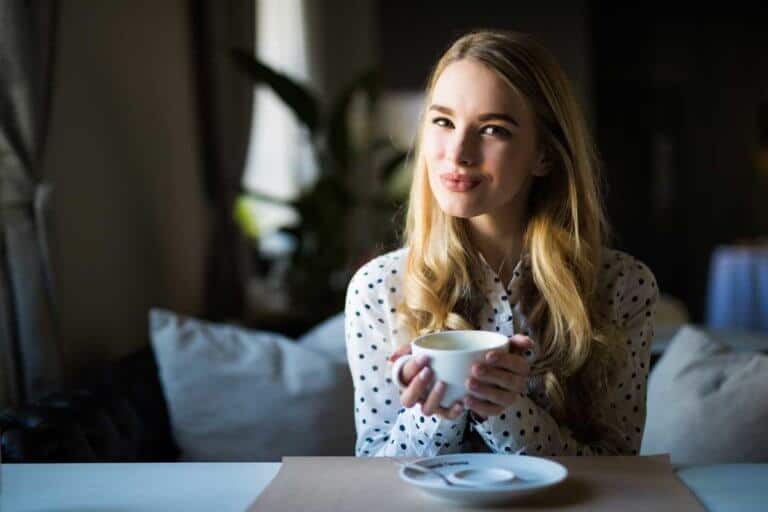 Junge Frau hält Kaffeetasse.
